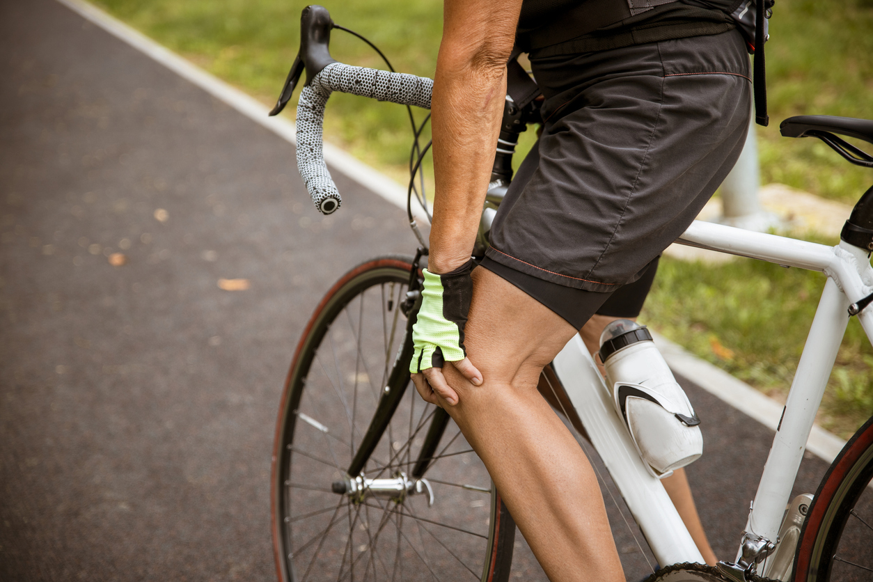 homme à vélo qui ressent une douleur au genoux