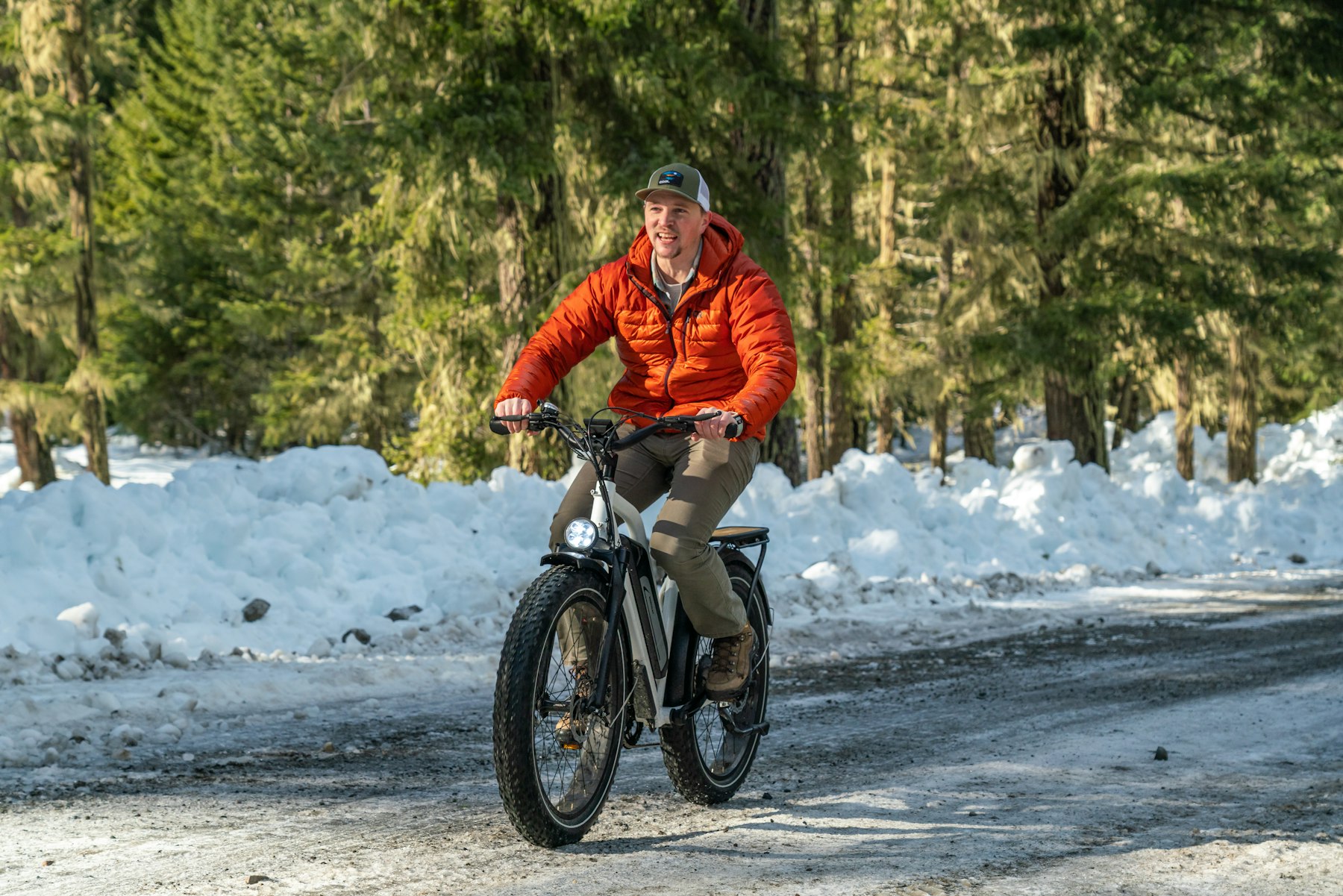 Cycliste en fatbike sur une route enneigée par une journée ensoleillée